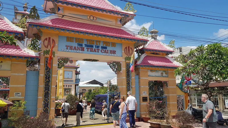 Visitors pass through the ornate gate of the Cao Dai temple in Cai Be, Mekong Delta.